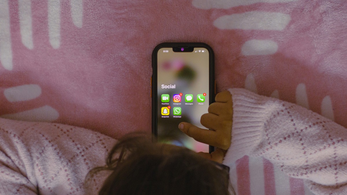 Een kind gebruikt een smartphone.
