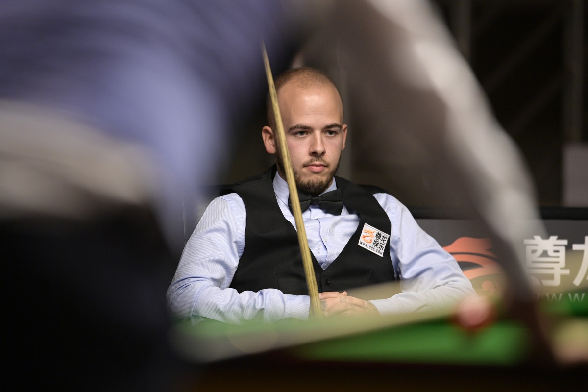 Luca Brecel zit bij een tafel van snooker