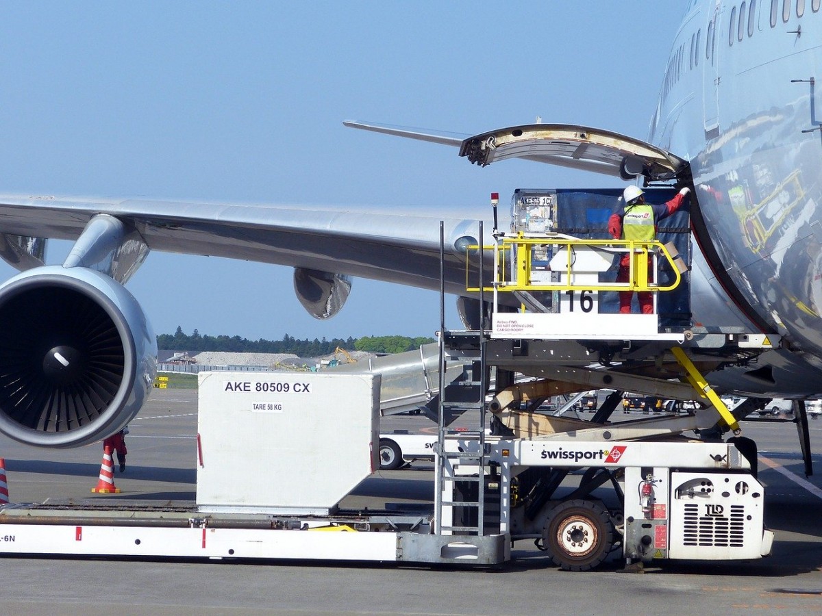 Swissport aan het werk met koffers bij een vliegtuig